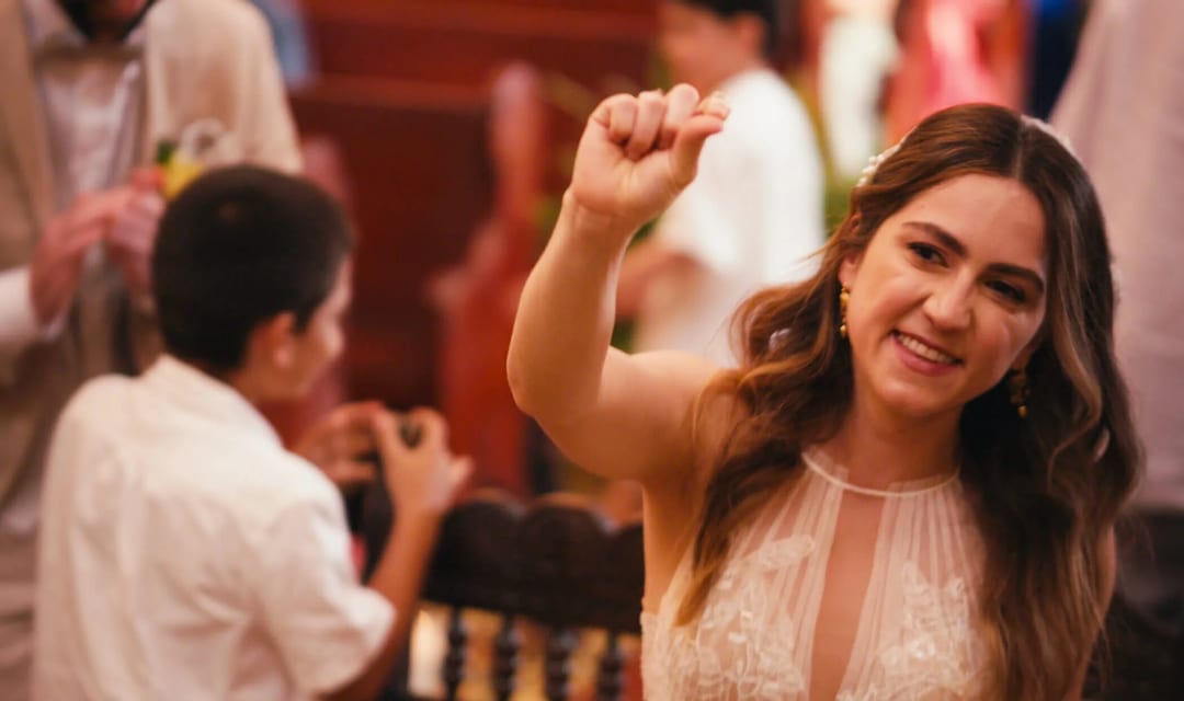 Bride Mariana joyfully tosses her wedding bouquet at the reception after marrying Alex.
