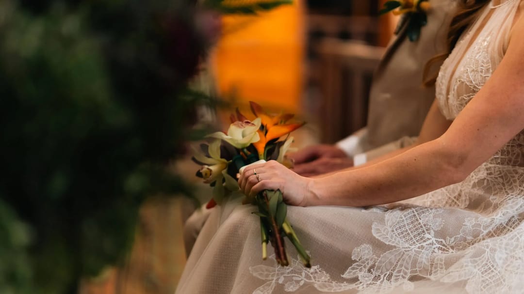 Bride holding her bouquet during the Mariana & Alex wedding ceremony.
