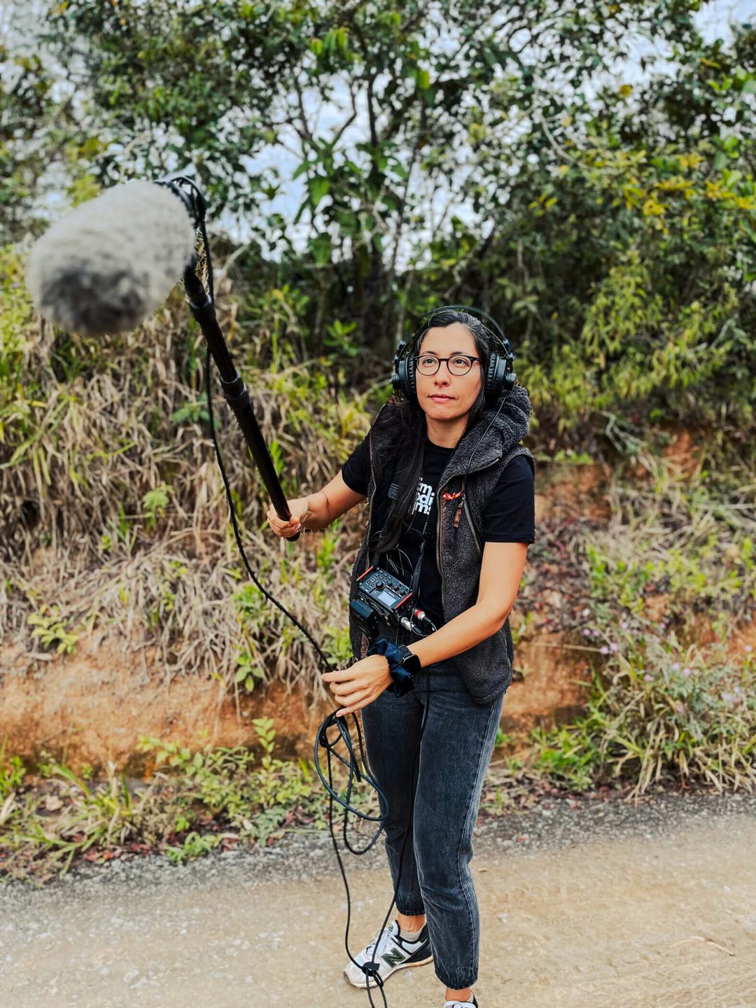 Cris Buri monitoreando sonido con un micrófono de pértiga en exteriores.