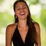 A smiling woman with long hair against a blurred green background.